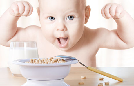 photo of happy baby with bowl of cereal