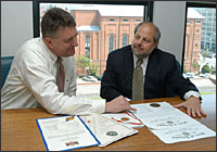 Two men look at electoral certificates at the Federal Register