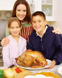 Madre e hijos reunidos alrededor de un pavo al horno