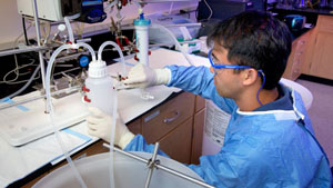 Image of a man using water in the laboratory for an experiment