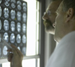 Two male doctors looking at X-Rays and MRI scans, pointing at scan