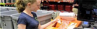 Girl recycling a CFL at a hardware and home supply store