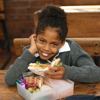 photo of a girl eating a sandwich