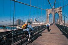  Image: Two bicyclists riding over the Brooklyn Bridge.