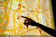 Hand pointing to a location on a map.