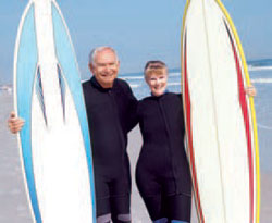 A man and woman holding surfboards