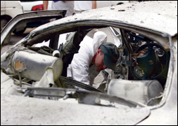 An FBI agent collects evidence from an exploded car in Lebanon. AP Photo