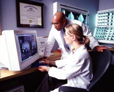 Photograph of a female doctor and a male doctor looking at an MRI scan of a brain