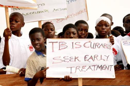 Boys holding up sign in Ghana that TB is cureable