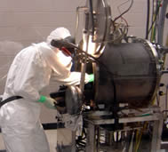 Worker removing carbon nanotubes from a furnace reactor