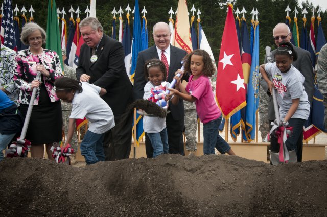 Undersecretary of the Army Joseph W. Westphal (back row, center) and Congressman Norm Dicks (back row, left of center) along with school district representatives and students shovel dirt on the future site of Joint Base Lewis-McChord's Hillside Elementary School during a groundbreaking ceremony signifying the official start of a yearlong construction project to completely rebuild Hillside and Carter Lake Elementary Schools within the next year, July 30, 2012, at Joint Base Lewis-McChord, Wash.  Westphal visited the base to gain situational awareness of the progress of the ACAP program, to help break ground on a school rebuilding initiative, and to inspect advances in telecommunication healthcare.