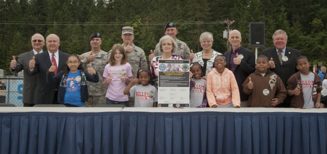 Civil and Military Leaders along with local school children stand proud at Joint Base Lewis-McChord, Wash., right after signing an Education of Military Children Covenant during a groundbreaking ceremony signifying the official start of a yearlong construction project to completely rebuild the installation's Hillside and Carter Lake Elementary Schools, July 30, 2012, at Joint Base Lewis-McChord, Wash. Westphal visited the base to gain situational awareness of the progress of the ACAP program, to help break ground on a school rebuilding initiative, and to inspect advances in telecommunication healthcare.
