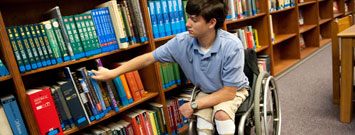 Foto de un niño con espina bífida en una silla de ruedas.