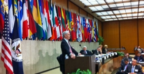 Bryson flanked by flags at the State Department
