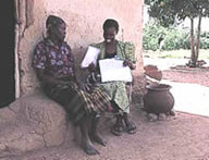 A health worker interviewing a member of the community during a malaria bed net study, Asembo Bay, Kenya. (Courtesy KEMRI)