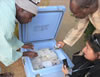 A “cold chain” officer (left) in Nigeria checks to be sure polio vaccine vials are correctly packed.