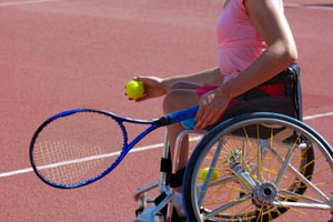 woman playing tennis in a wheelchair