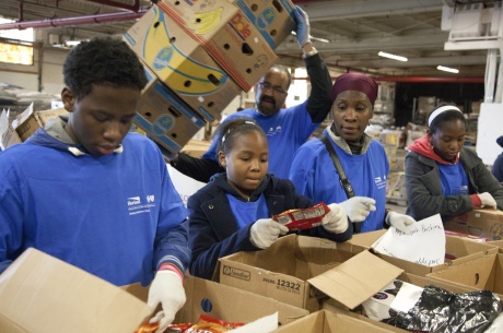 Hillside, N.J., Nov. 5, 2011 -- Tawfeeg Bashiru (left), Safiyyah Bashiru (center), and their mother Ayesha Bashiru (right), family volunteers from Horizon Blue Cross Blue Shield of New Jersey, help sort and pack donated food at the Community Food Bank of New Jersey. The Food Bank is a state member of Feeding America, a national organization that is a member of the National Voluntary Organizations Active in Disasters (VOAD). Photo by Christopher Mardorf / FEMA. 
