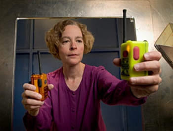 NIST engineer Kate Remley holds two Personal Alert Safety System (PASS) devices with wireless alarm capability (Photo copyright Paul Trantow/Altitude Arts)