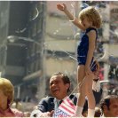 Photo: D0685-17   President Nixon and Pat Nixon stand out the window of their limo waving to the crowd near a child dressed as a majorette holding a baton, during a campaign stop parade in Atlanta, Georgia. 8/12/1972