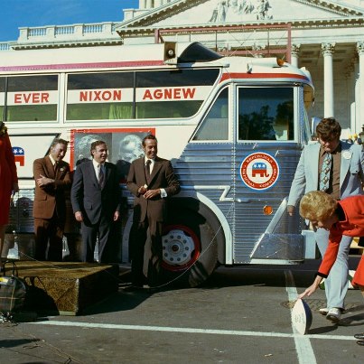 Photo: D0636c-20
Republican National Committee cross-country campaign swing kickoff ceremony.  First Lady Pat Nixon holds a football for the "kickoff." Senator Bob Dole, the RNC Chairman, stands by the bus front wheel, while Anne Armstrong, officiates on the podium. October 9, 1972.