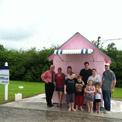 Photo: The Ochopee, Florida Post Office (the smallest Post Office in the nation) is going pink for the month of October to support Breast Cancer Awareness Month!  Postmaster Nanette Watson wants to sell more Breast Cancer Research First-Class Semipostal Stamps than any other Post Office during the month of October.

The stamp is sold in sheets of twenty 55-cent stamps and by law, 70 percent of the net amount raised is given to the National Institutes of Health and 30 percent is given to the Medical Research Program at the Department of Defense.  Since 1998, the stamp has raised over $75 million for breast cancer research.

Yesterday, at 3:30 p.m., the pink transformation will begin, thanks to students from Everglades High School who have volunteered to paint the Post Office.  

“The Ochopee Post Office may be small, but I am hopeful that customers will purchase enough Breast Cancer Research stamps from this Post Office to make a big difference,” said Watson.

Customers around the globe can purchase stamps from the Ochopee Post Office without a personal visit. Stamps can be purchased by mailing a check payable to Postmaster to:  Ochopee Postmaster, 38000 Tamiami Trail E, Ochopee FL  34141-9998.  The Breast Cancer Research Semipostal First-Class Stamps cost $11.00 per sheet.  Customers should include a return address and their purchase will be mailed to them in an envelope bearing the collectible “Nation’s Smallest Post Office” postmark.