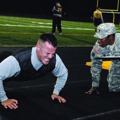 Photo: Staff Sgt. Craig Wayman shows his determination to complete as many pushups as possible during the Best Warrior Competition Army Physical Fitness Test event Tuesday morning at Williams Stadium. Wayman is a senior medic stationed at Fort Detrick Md., and is representing the U.S. Army Medical Command at Best Warrior. Also pictured is Sgt. 1st Class Charles Hutchison, a senior leader from the 530th Sustainment Support Battalion. (Photo by Patrick Buffett)
