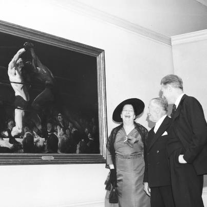 Photo: In 1957, the art of George Bellows was the subject of the Gallery’s first retrospective exhibition focused on the work of a single artist.  “A Retrospective of the Work of George Bellows” (January 19–February 24, 1957) was installed in the West Building Ground Floor Central Gallery and in adjacent rooms, where most temporary exhibitions were shown at the time. The Gallery had undertaken the exhibition with the encouragement of the great collector and Gallery trustee Chester Dale, who had been Bellows’ friend and patron. In 1945, exactly 20 years after the artist’s death, Dale presented the Gallery with the first works by the artist to enter the collection, including “Both Members of this Club” (1909). Don’t miss this boxing masterpiece in “George Bellows,” currently on view in the West Building through October 8!

Image: Mrs. George Bellows, Chester Dale, and Gallery Director John Walker with “Both Members of this Club” at the exhibition opening preview, January 19, 1957. National Gallery of Art, Washington, D.C., Gallery Archives