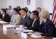 Secretary Locke seated at table with Board  participants. Click for larger image.