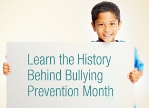 Boy holds sign on history of bullying prevention month. 