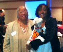 Photo: Rev. Angela Lundy and Rosalind McKelvey (holding Rev. Lundy's assist dog, Iris) at the Second Annual Functional Needs Symposium on October 2, 2012. The theme of the event was, "Emergency Communication: Are You Speaking the Right Language?" and the focus was on emergency communications for people with sensory disabilities.