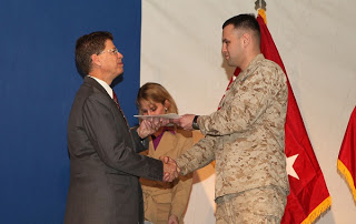 Marine Cpl. Yevgeniy Levin receives his Certificate of Naturalization from Robert Looney, USCIS Bangkok District Director during a naturalization ceremony on Kandahar Airfield in Afghanistan on Jan. 29. (Photo courtesy of the U.S. Marine Corp)