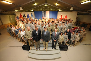 98 new U.S. citizens after their naturalization ceremony in Kandahar, Afghanistan with U.S. Army Maj. Gen. James L. Terry; Karl W. Eikenberry, U.S. Ambassador to Afghanistan; Congressman Darrell Issa; and Robert Looney, USCIS Bangkok District Director. (Photo courtesy U.S. Air Force.)