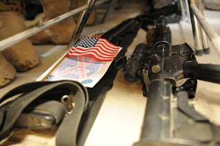 Servicemembers placed their weapons underneath their seats during the USCIS naturalization ceremony held Jan. 29 on Kandahar Air Field in Afghanistan. (Photo courtesy U.S. Air Force)