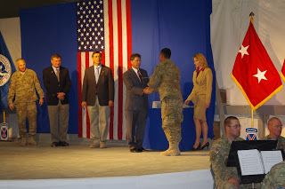 USCIS Immigration Assistant Traci Picciano, right, watches as a new citizen receives his Certificate of Naturalization from USCIS Bangkok District Director Robert Looney and congratulations from Congressman Darrell Issa, Ambassador Karl Eikenberry, and Maj. Gen. James L. Terry, 10th Mountain Division commander
