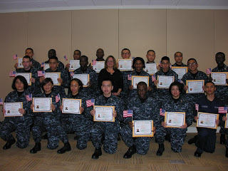 USCIS Chicago District Director Ruth Dorochoff stands with a group of newly naturalized Navy recruits
