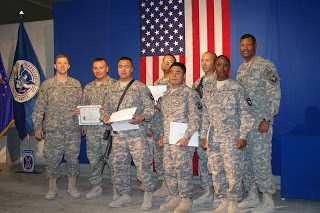 Six new citizens stand with their brigade commander and Command Sgt. Maj.