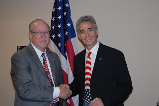 Jon Stettner (right) shakes hands with Charles Harrell, Acting Director of the USCIS Phoenix Field Office