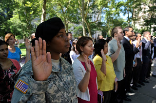 Army PFC Lafiette Trowers joins her fellow new citizens in taking the Oath of Allegiance