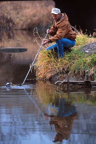 ARS Technician Jeff Nichols collects a water sample from the Walnut Creek watershed in Ames, Iowa.