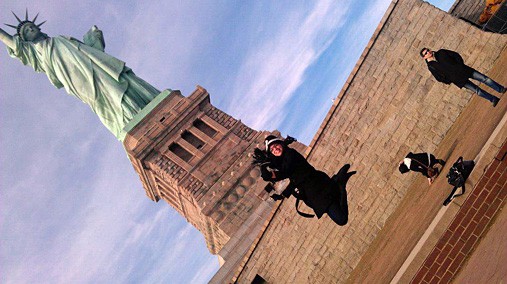 Vanessa Colon, the author, jumps in front of the Statue of Liberty in New York, undated. [Photo Used by Permission]