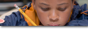 A boy writing with a pencil