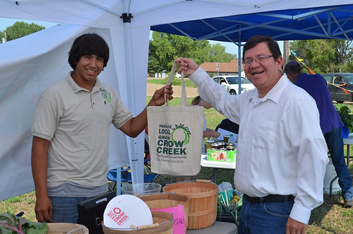 Crow Creek Fresh Food Initiative employee Wyatt Fleury at the Farmer’s Market with Kevin Yellow Bird Steele.  With USDA support, a Farmers market is thriving in Ft. Thompson.  
