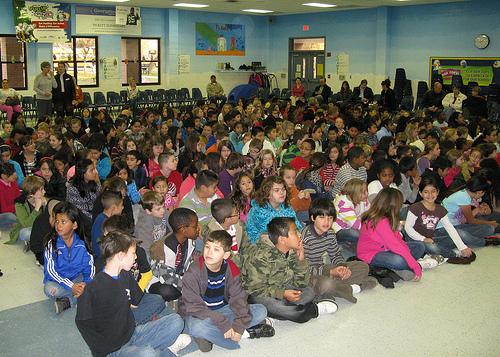 Children listen attentively to the award ceremony.