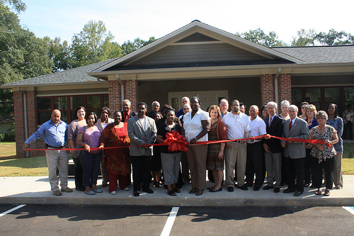 State Director Trina George, the Hospital Administrator, Calvin Johnson, the Kilmichael Clinic physician, Dr. Katrina Poe, and attendees cut the  ribbon prior to the touring the new clinic.