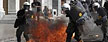 Flames from a molotov cocktail flare up near Greek riot police. (Reuters)