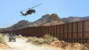 A CBP vehicle patrols the border fence between the United States and Mexico.