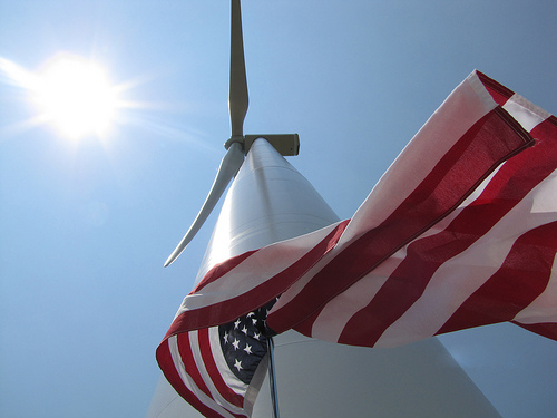 An American flag flies next to a new wind turbine, funded in part through USDA support. USDA photo.