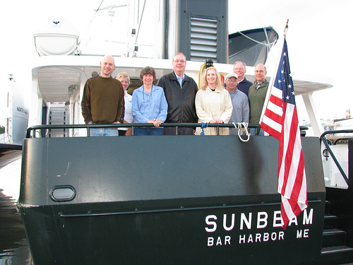 USDA Rural Development Under Secretary Dallas Tonsager (center)  and Maine State Director Virginia Manuel (Right of the Under-Secretary)  stand on the deck of the Sunbeam with its staff and crew in Rockland Harbor.  The Sunbeam travels to Maine islands to provide medical treatment to residents.