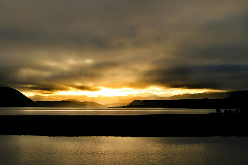 The sunrise over Lago Cucao with Chiloe National Park on the left shoulder of the slopes in background.  Photo courtesy of Michael Olwyler.
